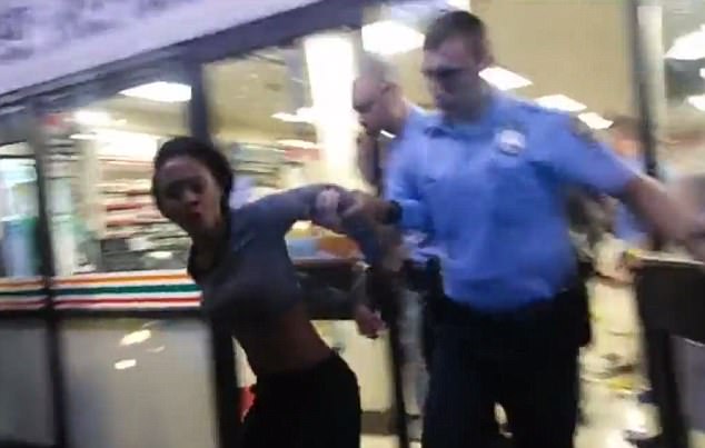 The woman yells as she is escorted from the store by an officer